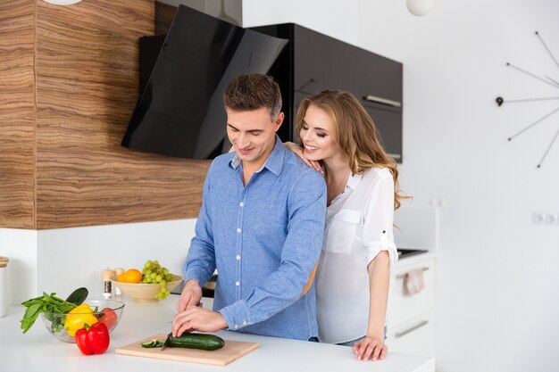 Gelukkig stel dat groenten snijdt voor salade en flirt in de keuken