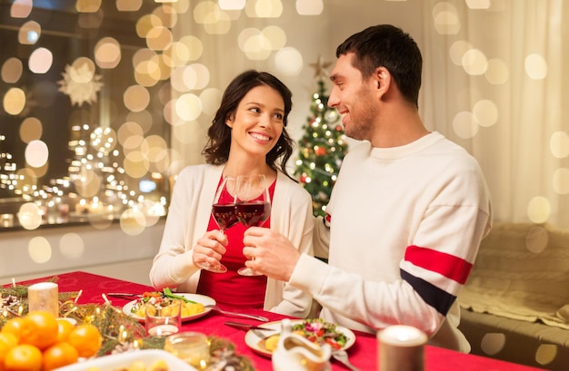 gelukkig stel dat rode wijn drinkt bij het kerstdiner