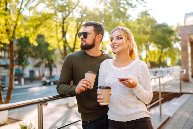 Foto gelukkig stel dat tijd samen doorbrengt, koffie drinkt, plezier heeft,'s morgens door de stad loopt.