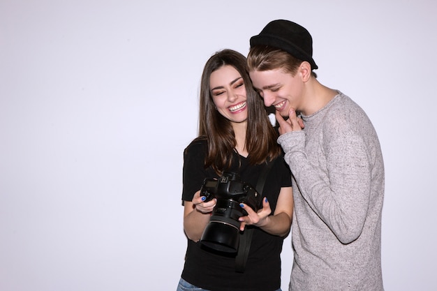 Gelukkig stel geniet met digitale camera op witte scène