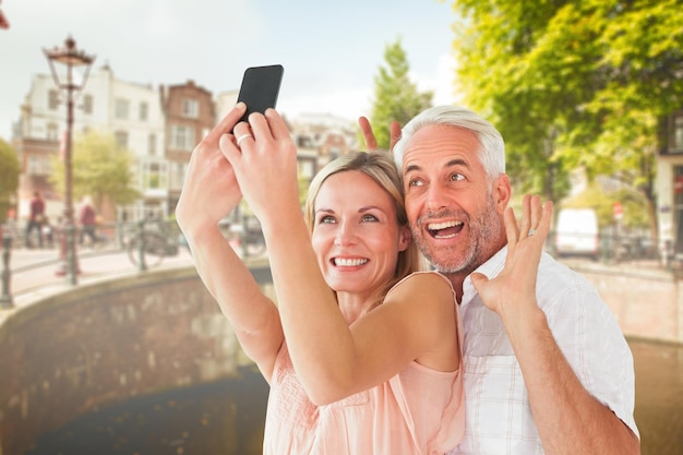 Gelukkig stel poseren voor een selfie tegen de brug in amsterdam