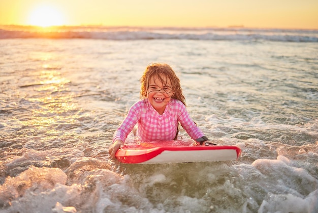 Gelukkig strand en meisje leren surfen voor sportmotivatie en hawaii zomervakantie Natuur reizen en glimlachen met kind surfen aan boord voor watersport splash en wellness oceaanvakantie