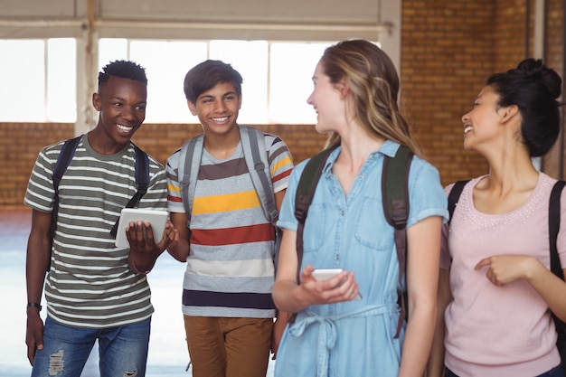 Gelukkig studenten interactie tijdens het gebruik van mobiele telefoon en digitale tablet op de campus