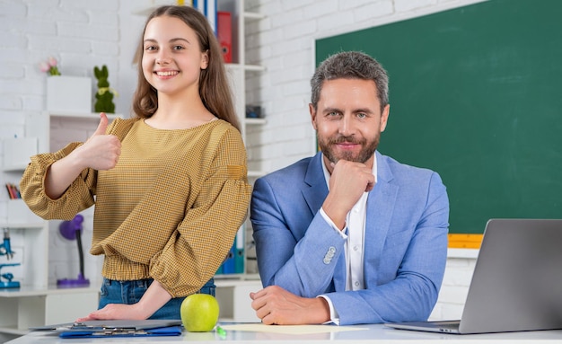 Gelukkig tienerkind met mensenleraar in klassikaal onderwijs