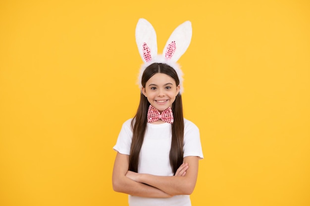 Gelukkig tienermeisje draagt konijnenoren. gelukkig Pasen. jeugd geluk. kind in konijnenoren en vlinderdas. tijd voor plezier. schattig kind dat er grappig uitziet. paasvakantie lente.