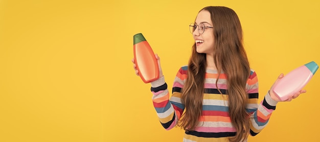 Gelukkig tienermeisje gebruik shampoo fles kind met haarconditioner dagelijkse gewoonten en persoonlijke verzorging Banner van kind meisje haarverzorging studio poster koptekst met kopie ruimte