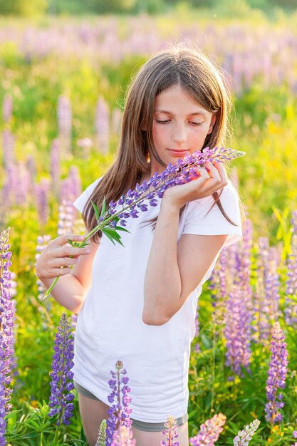 Gelukkig tienermeisje glimlachend buiten mooie jonge tiener vrouw rustend op zomer veld met blooming