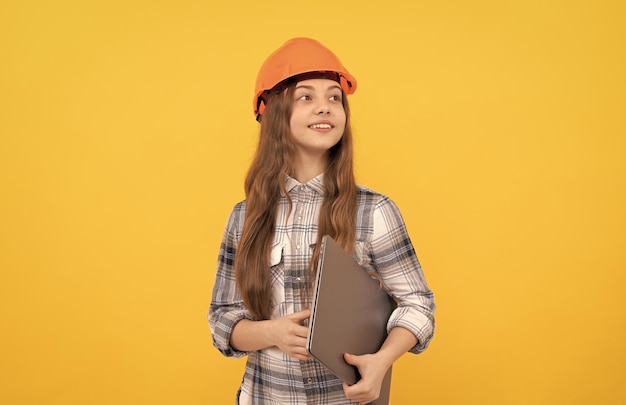 Foto gelukkig tienermeisje in helm en geruit overhemd die computer toekomstige carrière houden