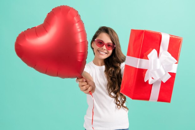 Gelukkig tienermeisje in zonnebril geven geschenkdoos en Valentijnsdag feest hart ballon valentijn