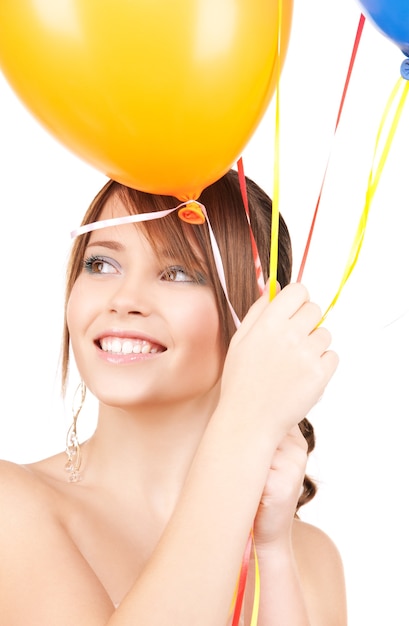 gelukkig tienermeisje met ballonnen over witte muur