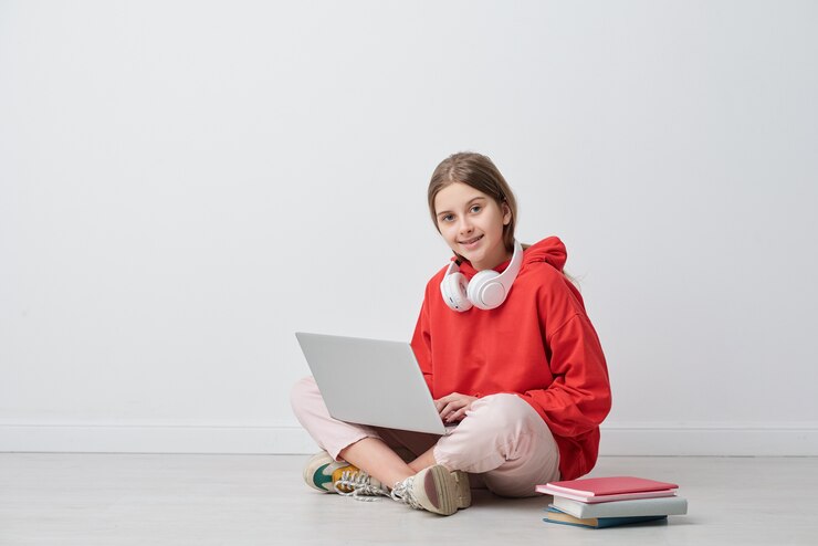 Foto gelukkig tienermeisje op zoek naar jou zittend voor de camera en studeren in het net tijdens thuisquarantaine geïsoleerd