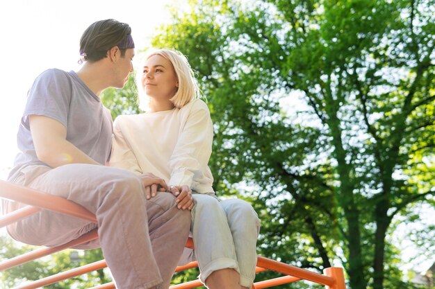 Gelukkig tienerpaar op speelplaats in een stadspark