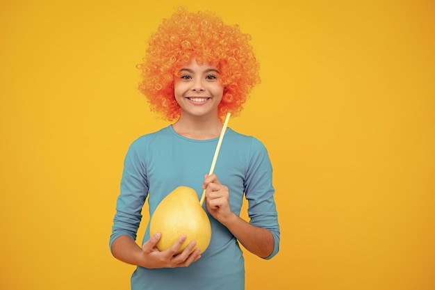 Gelukkig tienerportret Grappig kind meisje in pruik houdt grote citrusvruchten pummelo of pomelo vol vitamine gezonde kinderen eten Lachend meisje