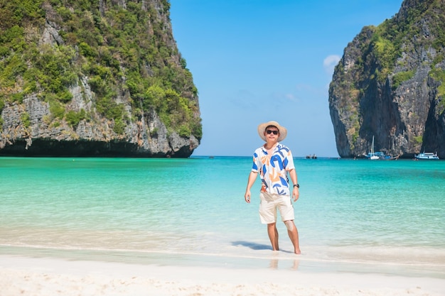 Foto gelukkig toeristische man op maya bay strand op phi phi eiland krabi thailand landmark bestemming zuidoost-azië reizen vakantie en vakantie concept