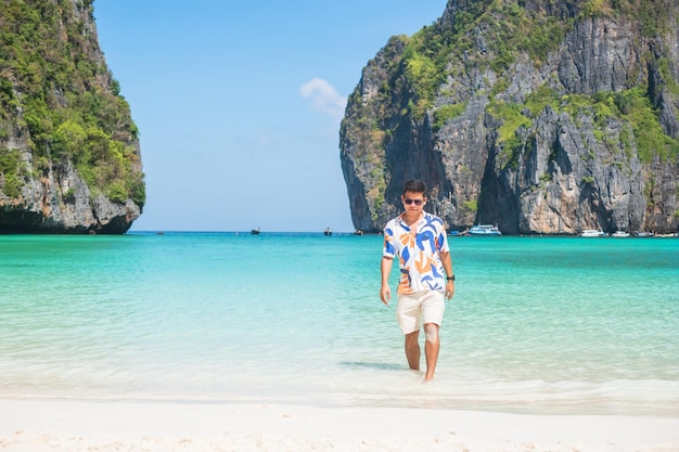 Foto gelukkig toeristische man op maya bay strand op phi phi eiland krabi thailand landmark bestemming zuidoost-azië reizen vakantie en vakantie concept