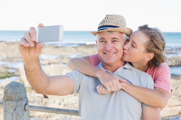 Gelukkig toevallig paar dat een selfie neemt door de kust