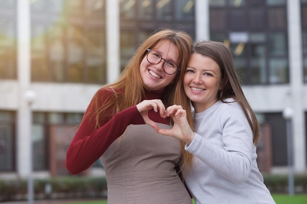 Gelukkig twee studenten jonge lesbische lgbt-vrouwen buiten op de campus gelukkige homoseksuele vrouwelijke familie