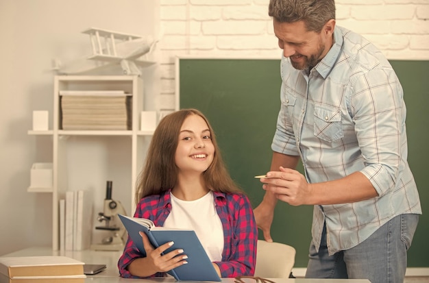 Gelukkig vader en kind studeren op school met boek over schoolbord achtergrondonderwijs