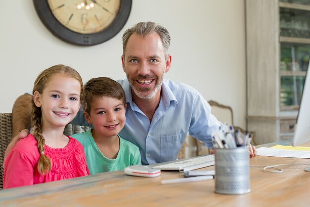 Gelukkig vader en kinderen zitten aan de balie