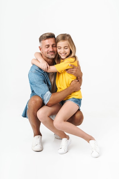 Gelukkig vader met zijn dochtertje omarmen geïsoleerd op wit