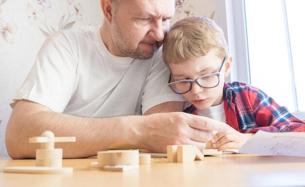 Gelukkig vaderdag- en jeugdconcept Vader en zoon in glazen werken met handgereedschap met behulp van