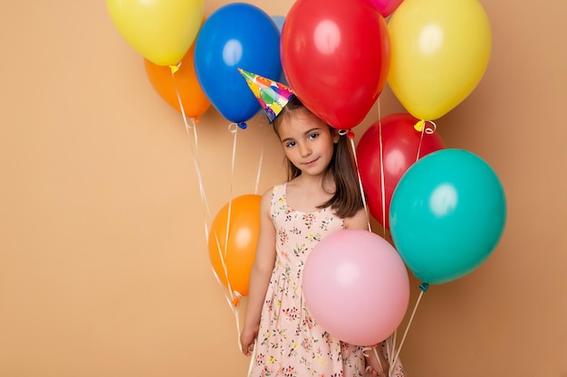 Gelukkig verjaardagsfeestje Kind meisje met ballonnen op beige achtergrond