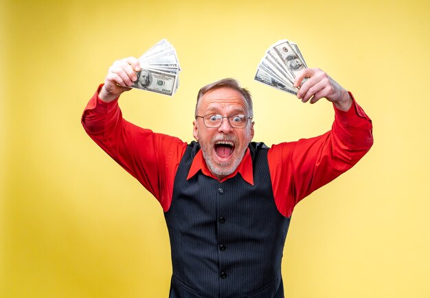 Foto gelukkig verlaten man in glazen en rood shirt met twee trossen geld