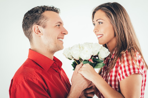 Gelukkig verliefde paar houden boeket witte rozen.