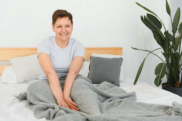 Gelukkig verse mooie volwassen oudere vrouw wakker na gezonde slaap stretch wakker in gezellig comfortabel bed glimlachende dame van middelbare leeftijd genieten van Goedemorgen kijken camera close-up portret bovenaanzicht