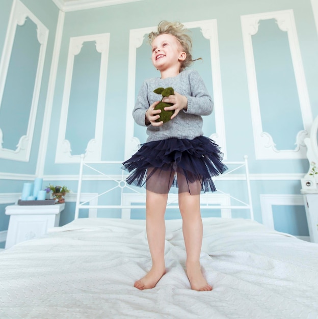 gelukkig vijf-jarig meisje springen op het bed