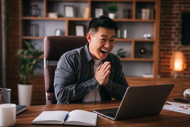 Gelukkig volwassen japanse man kijken naar laptop gebaren en begroeten hebben videogesprek met klant