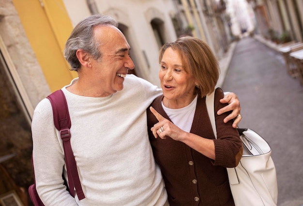 Gelukkig volwassen man en vrouw praten tijdens het wandelen in Lissabon