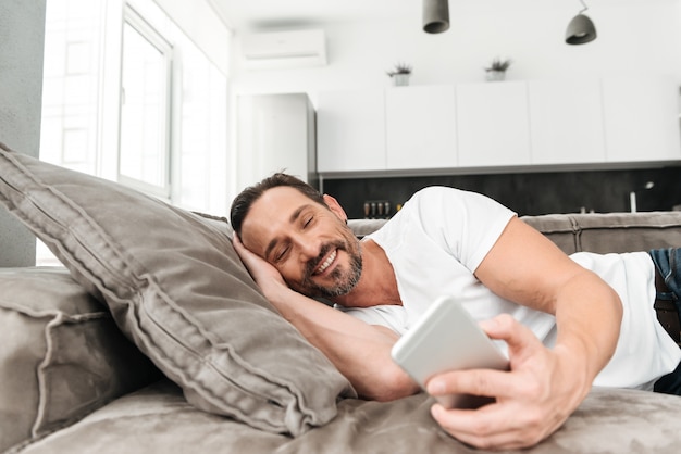 Gelukkig volwassen man met behulp van mobiele telefoon