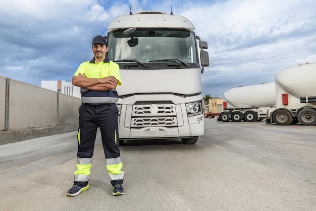 Gelukkig volwassen man monteur staande in de buurt van geparkeerde vrachtwagen