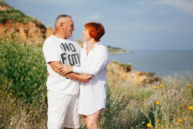 Gelukkig volwassen paar poseren op zonnige dag op het strand