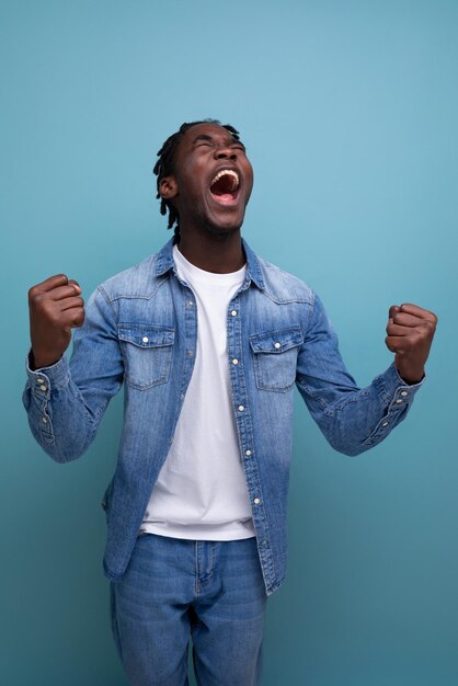 Gelukkig vrolijke afrikaanse man met krullend haar in een nonchalante look ervaart aangename emoties