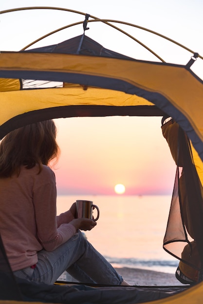 Gelukkig weekend aan zee - meisje in een tent op het strand bij zonsopgang. Oekraïens landschap aan de Zee van Azov, Oekraïne