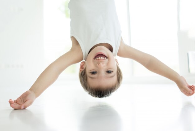 Gelukkig weinig babyjongen ondersteboven lachen thuis