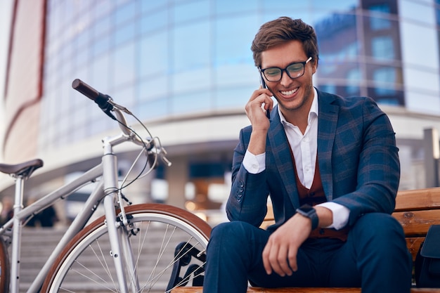 Gelukkig zakenman spreken op smartphone op straat