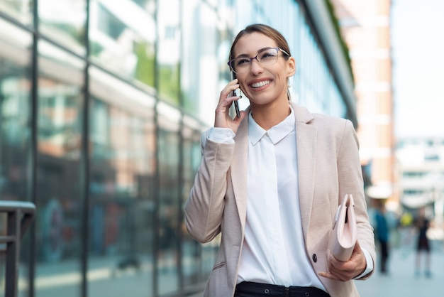 Gelukkig zakenvrouw praten aan de telefoon buiten