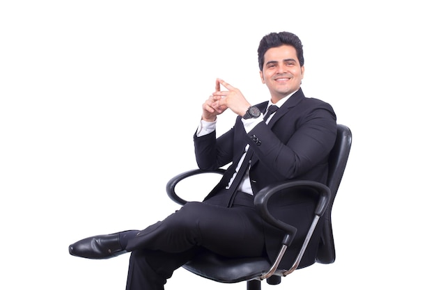 Gelukkig zelfverzekerde Indiase zakenman zittend op een bureaustoel en poseren met handen omhoog