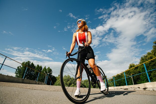 Gelukkig zomer lage hoek portret een vrouw fietser met krullend haar in een helm