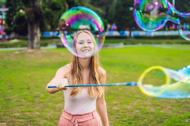 Gelukkig zorgeloze jonge vrouw zeepbellen blazen