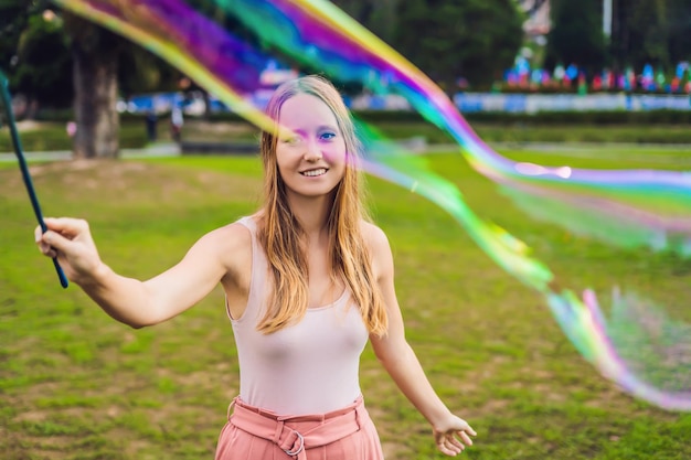 Gelukkig zorgeloze jonge vrouw zeepbellen blazen