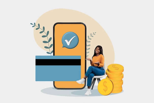 Gelukkig zwarte vrouw zitten in de buurt van enorme mobiele telefoon en creditcard kopen in webwinkel online maken