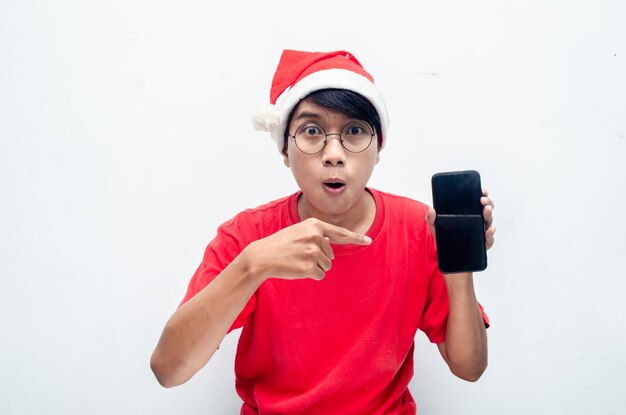 gelukkige aantrekkelijke Aziatische man in rode kerstthema-kleding schokte gelukkig terwijl hij de telefoon vasthield.