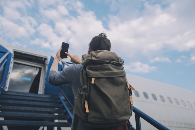 Gelukkige aantrekkelijke Aziatische vrouw reiziger met rugzak op de moderne luchthaven terminal kopie ruimte Toeristische reis reis concept