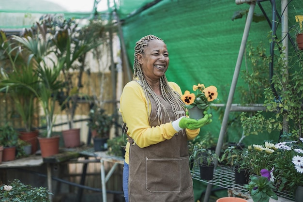 Gelukkige Afrikaanse vrouw die in het tuincentrum werkt