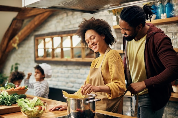 Gelukkige Afro-Amerikaanse ouders koken in de keuken