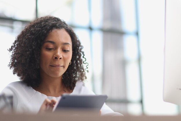 Gelukkige Afro-Amerikaanse zakenvrouw met een digitale tablet.